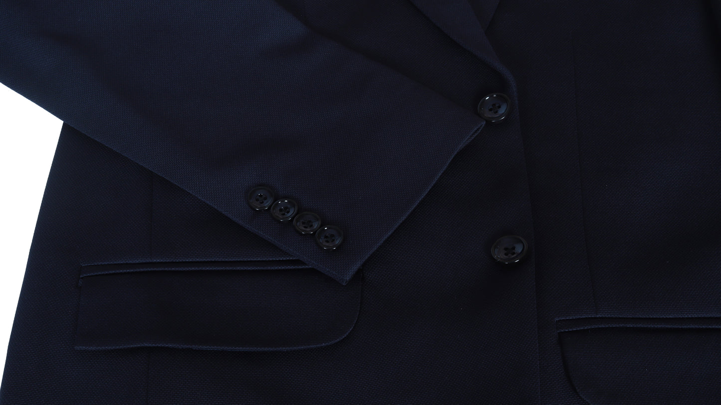 Close-up of a dark blue suit jacket sleeve with buttons on a white background