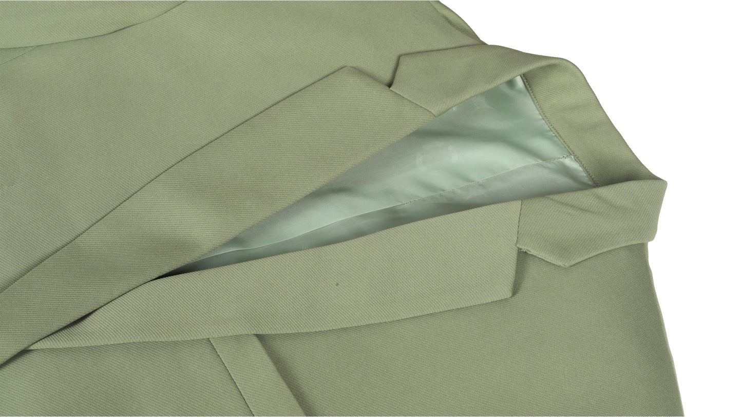 Close-up of a green coat fabric with a white interior lining on a white background