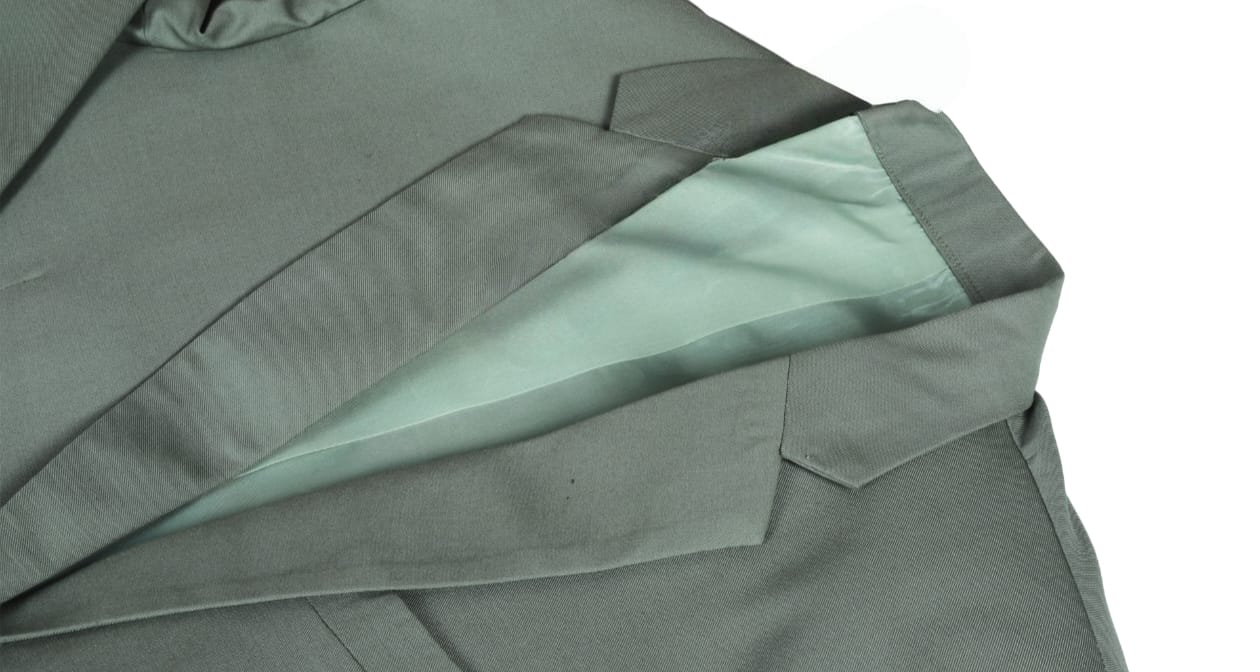 Close-up of a green coat with a collar and sleeve on a white background