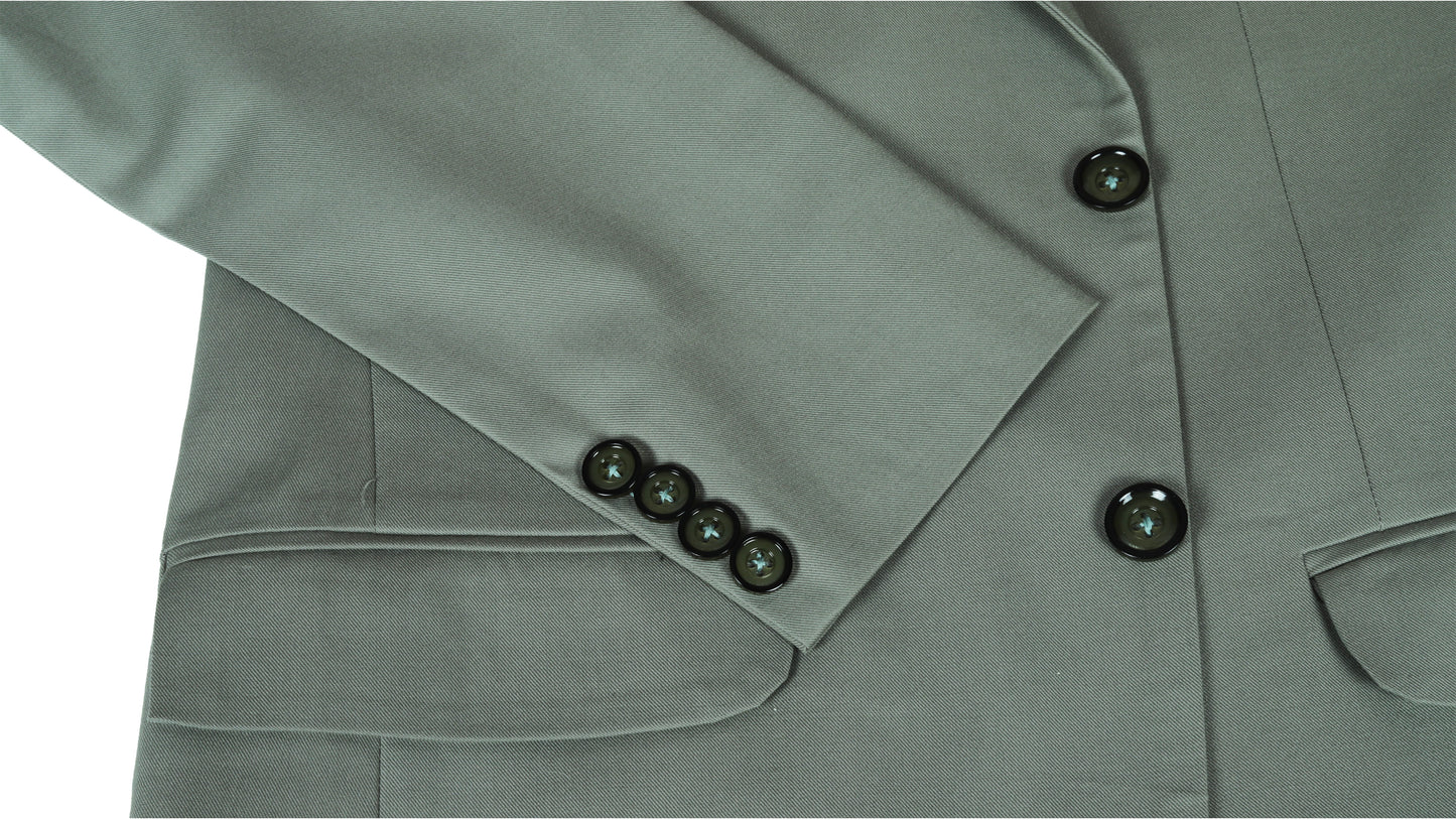 Close-up of a green suit jacket sleeve with buttons on a white background