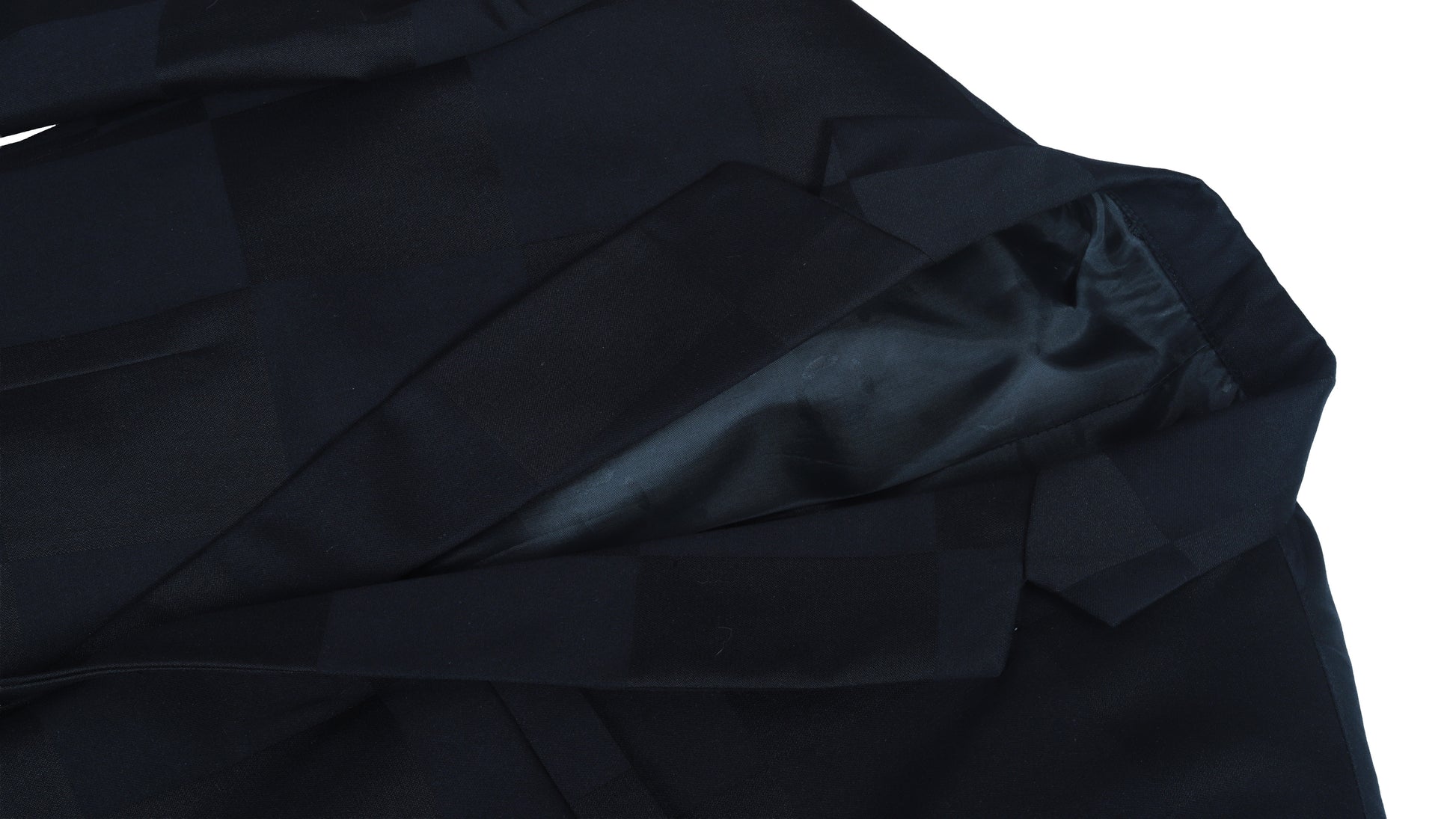 Close-up of black coat fabric with folds on a white background