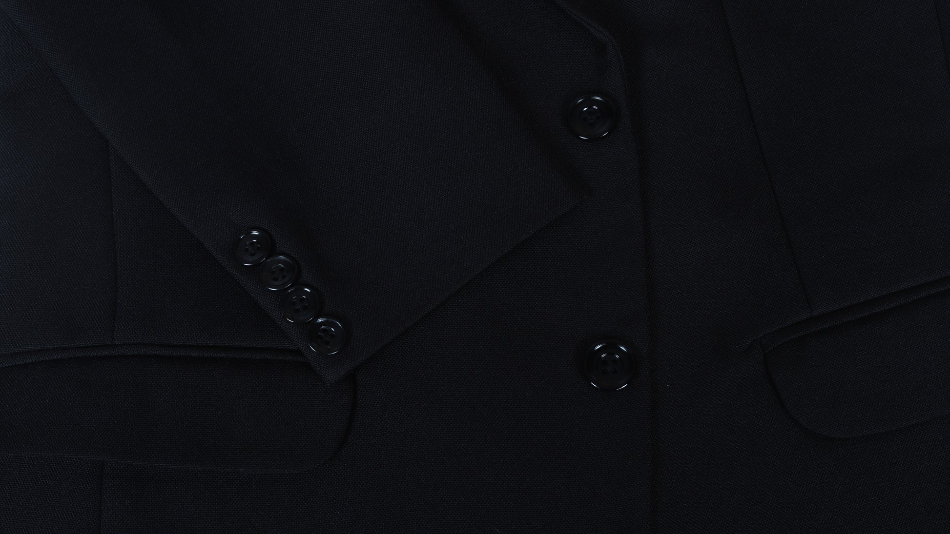 Close-up of a black coat sleeve with buttons